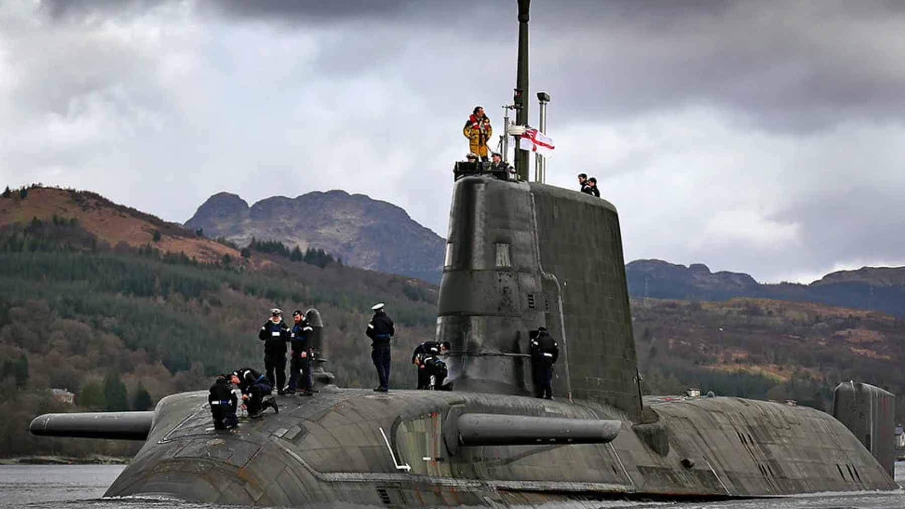 A Royal Navy Astute-class submarine moored at a naval facility during a period of maintenance and repair.