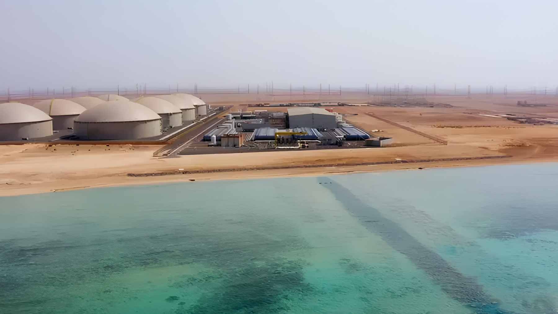 Aerial view of the Rabigh 4 desalination facility along the Red Sea coast, featuring large-scale reverse osmosis infrastructure and water storage tanks.