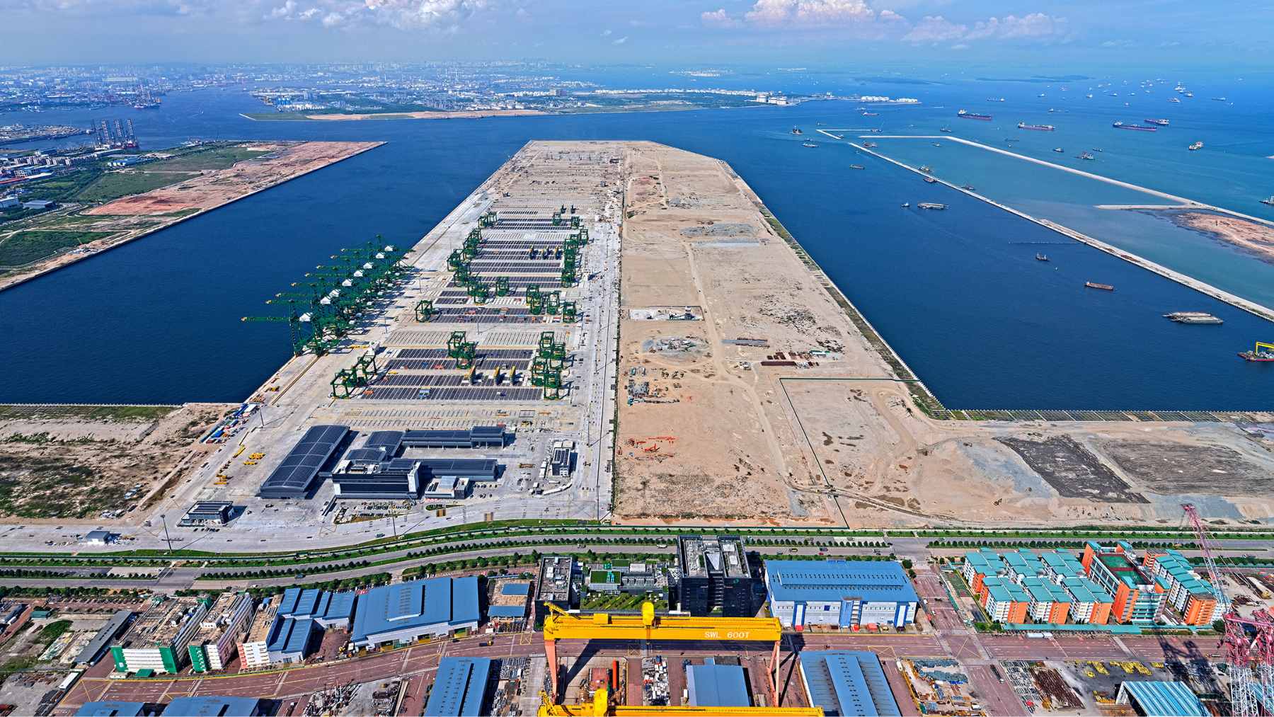 Massive concrete caissons being installed to form the seawall of the Tuas Port expansion in Singapore.