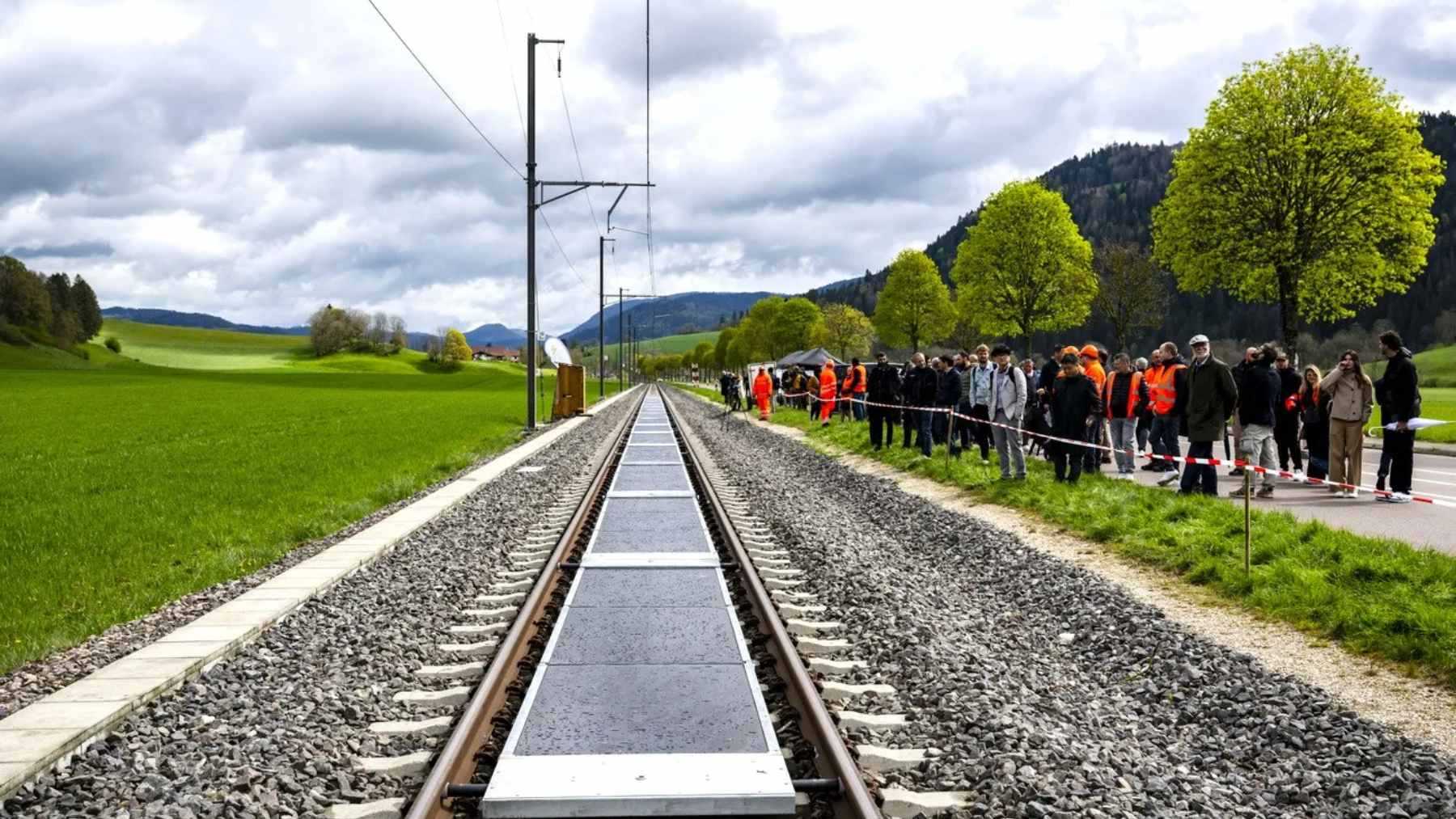 A section of an active Swiss railway track featuring removable solar panels installed between the steel rails to generate clean electricity.