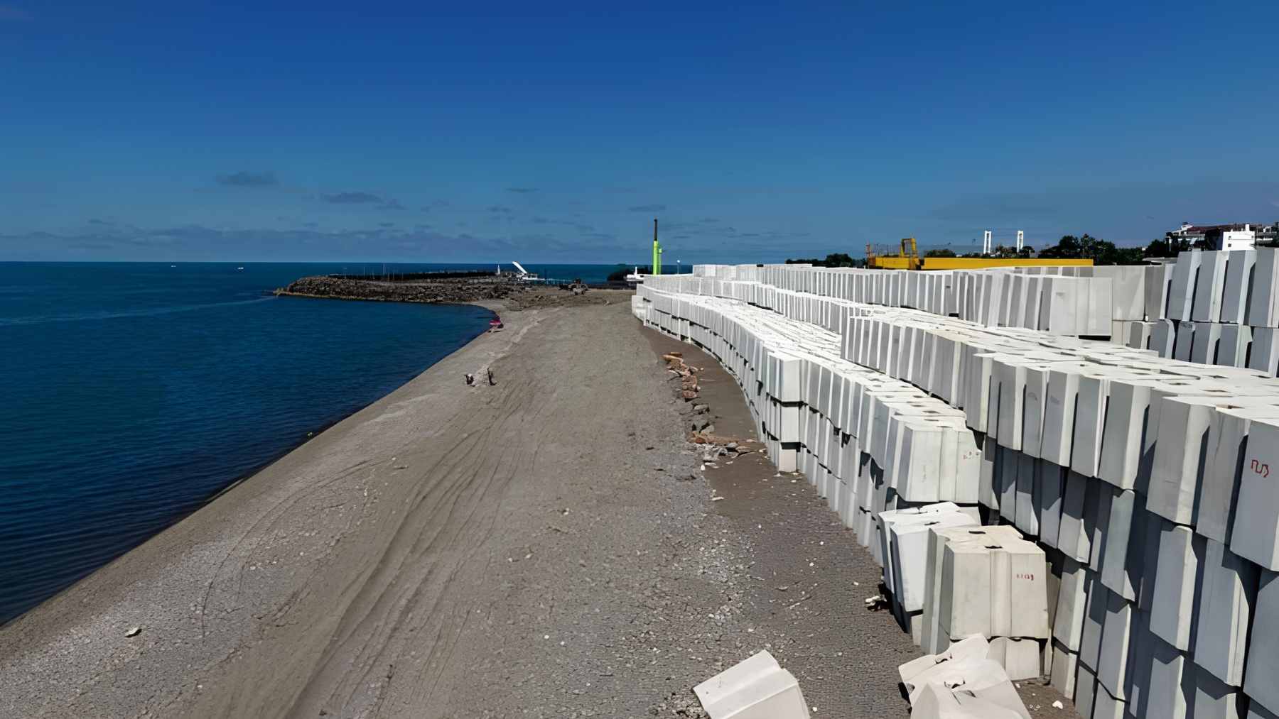 Heavy machinery and cranes placing 21-metric-ton concrete blocks to reinforce the breakwater at Faroz Port in Trabzon.