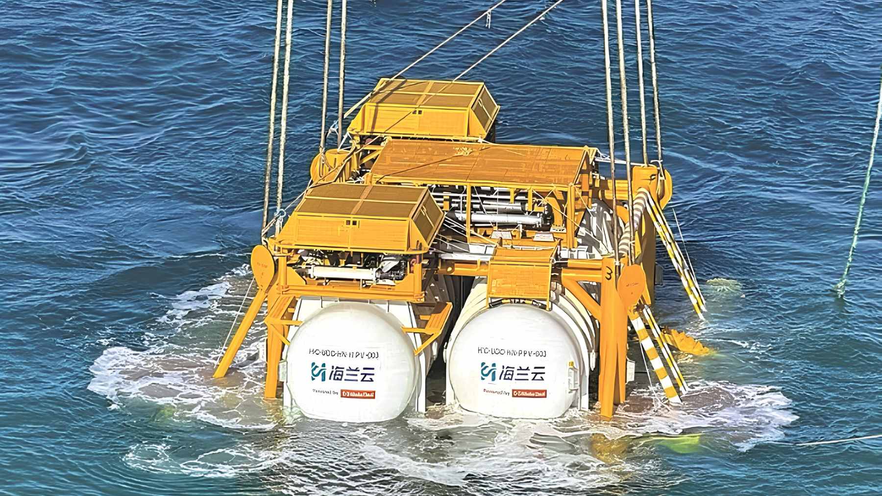 An offshore subsea data center module being submerged off the coast of Shanghai, integrated with nearby wind power infrastructure.