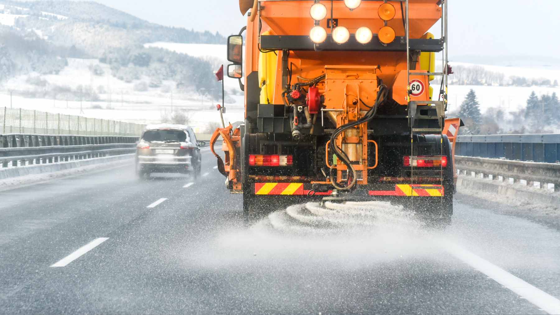 Pickle juice, molasses and beer residue are replacing road salt, turning industrial waste into infrastructure chemistry 1 A municipal snowplow spraying a road with a tinted liquid mixture of brine and beet juice as an alternative to traditional rock salt.