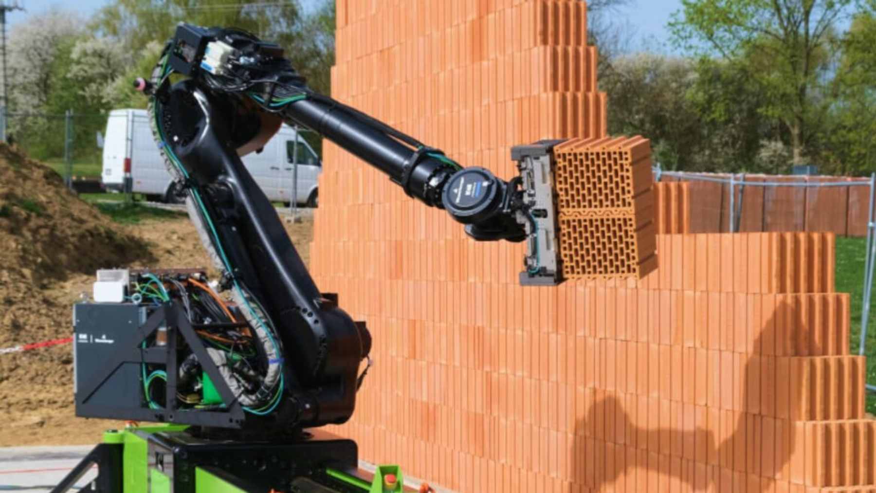The WLTR masonry robot autonomously laying bricks on a residential construction site using adhesive foam.