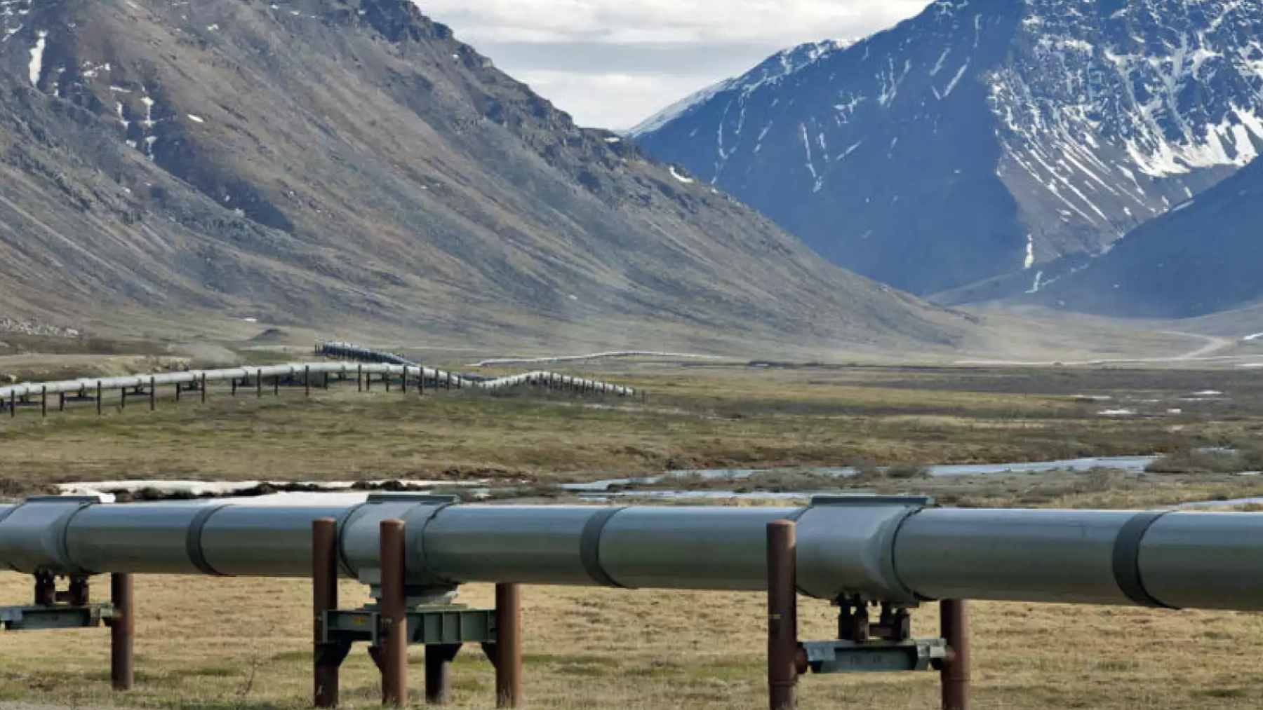 A confidential document just revealed the real terms behind one of the world's largest planned gas pipelines in Alaska 1 A section of industrial pipeline traversing the Alaskan landscape, representing the scale of the proposed $50 billion Alaska LNG project.