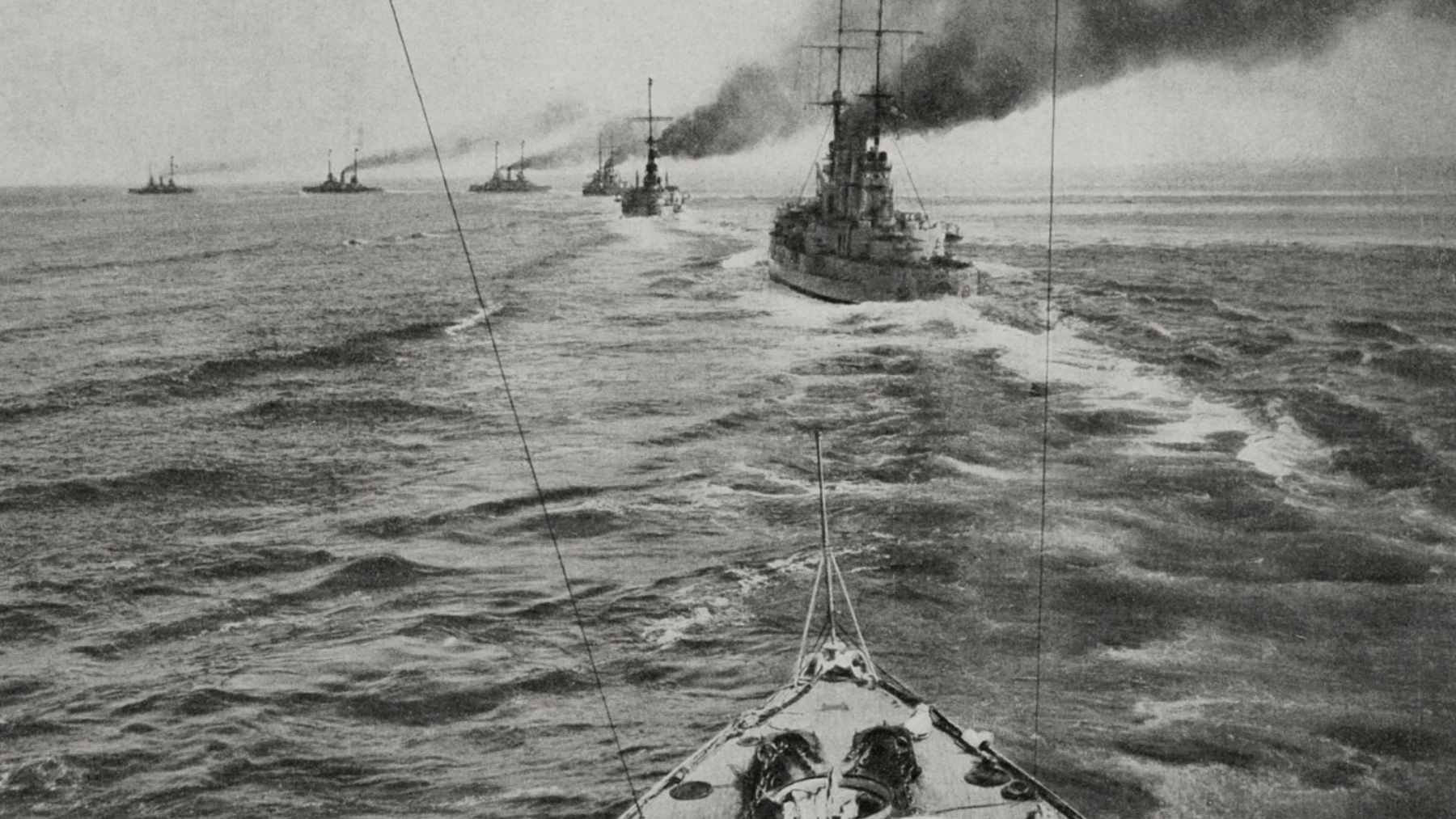 A historic photograph of British and German warships exchanging fire during the 1916 Battle of Jutland.