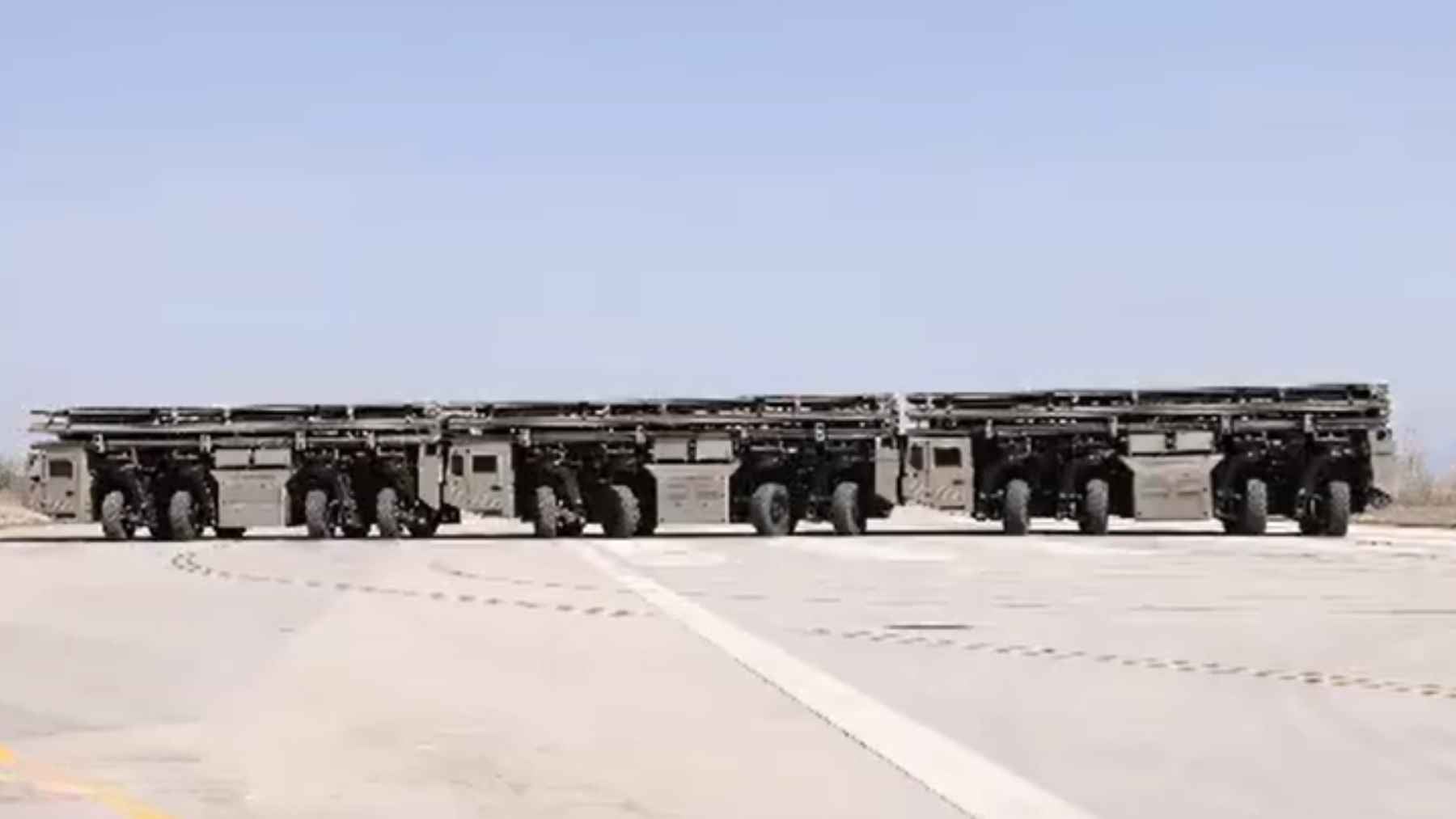 An electromagnetic catapult launch system mounted on a convoy of multi-wheeled trucks, demonstrating mobile fixed-wing drone launch technology in China.