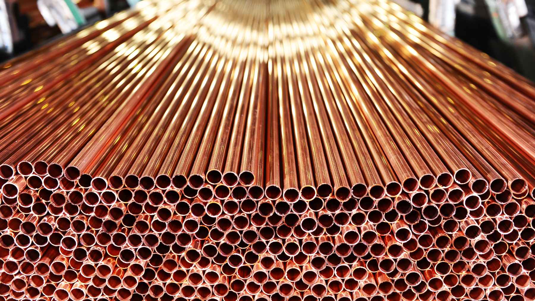 Piles of refined copper wiring and metal materials stacked in a global industrial supply chain warehouse.