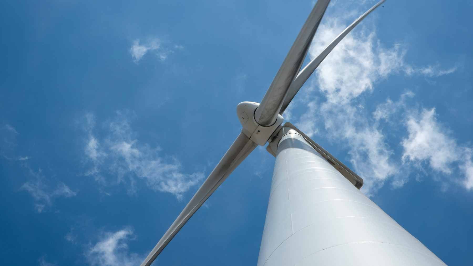 Hungary just cleared 70 wind turbines across three counties in a first-ever permit that could reshape its power grid 1 Modern utility-scale wind turbines installed in a rural agricultural landscape, representing renewable energy expansion.