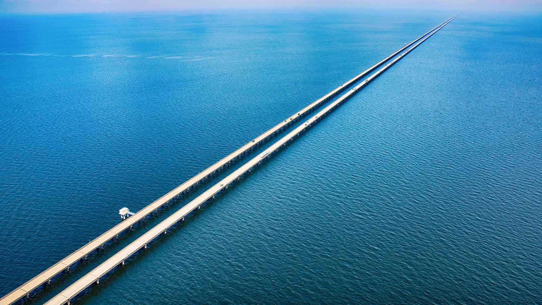 An aerial view of the twin spans of the Lake Pontchartrain Causeway stretching across the horizon in Louisiana.
