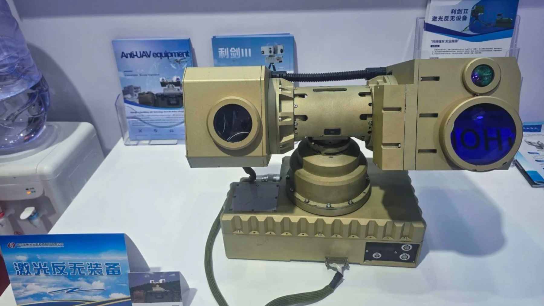 A soldier carrying the backpack-sized Lijian III portable anti-drone laser system at a defense exhibition.