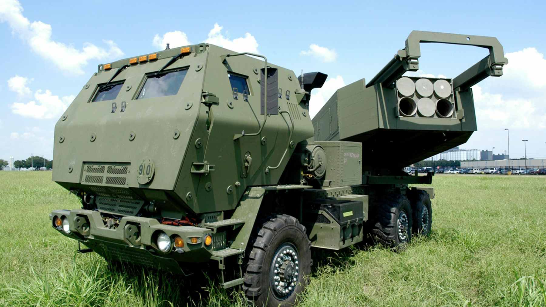 Advanced HIMARS and M270 rocket artillery launchers deployed in a field during military exercises.