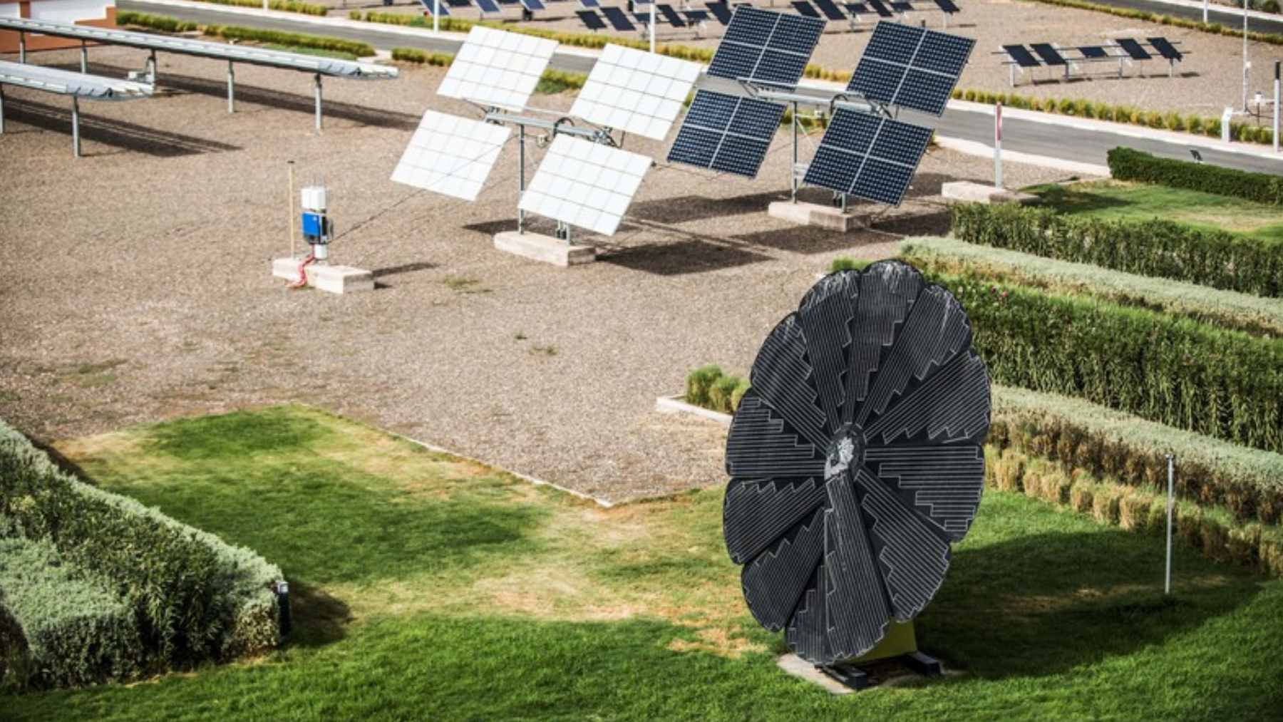 Large-scale solar panels and wind turbines installed in a desert landscape to power green energy industrial facilities.