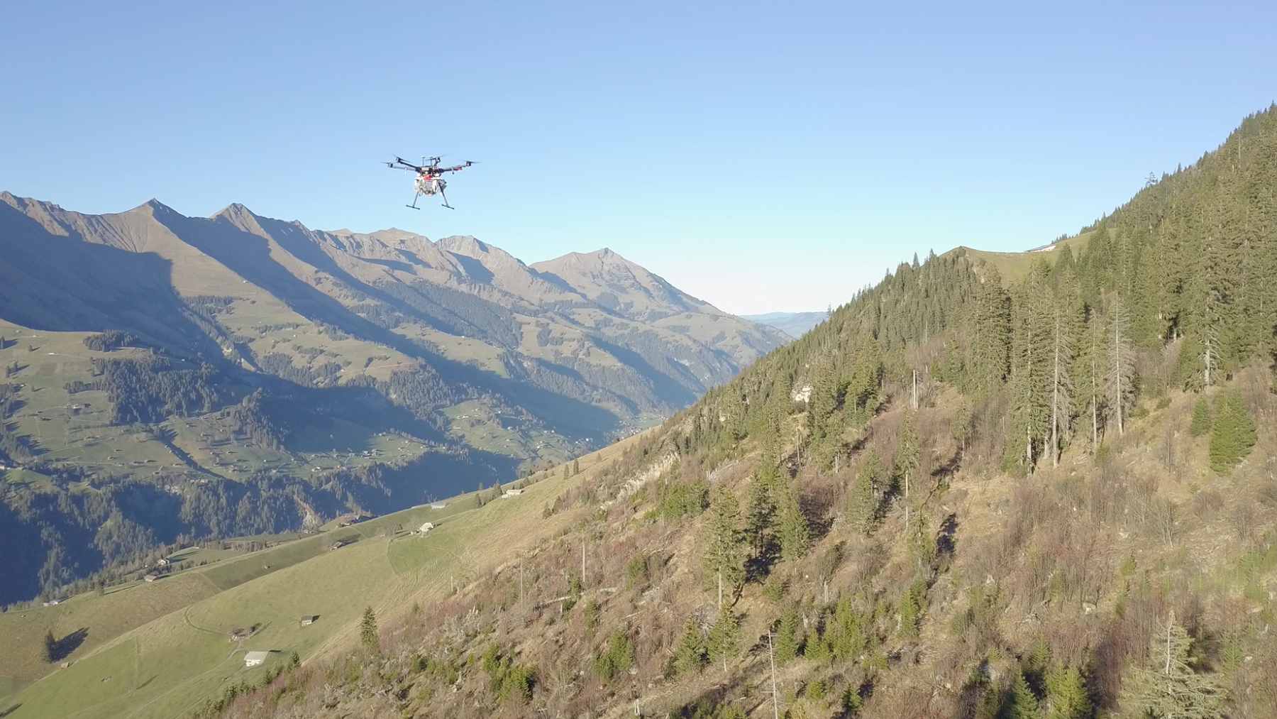 A Flying Forests drone equipped with a rapid-fire launcher dispensing nutrient-rich seed balls over a deforested landscape.