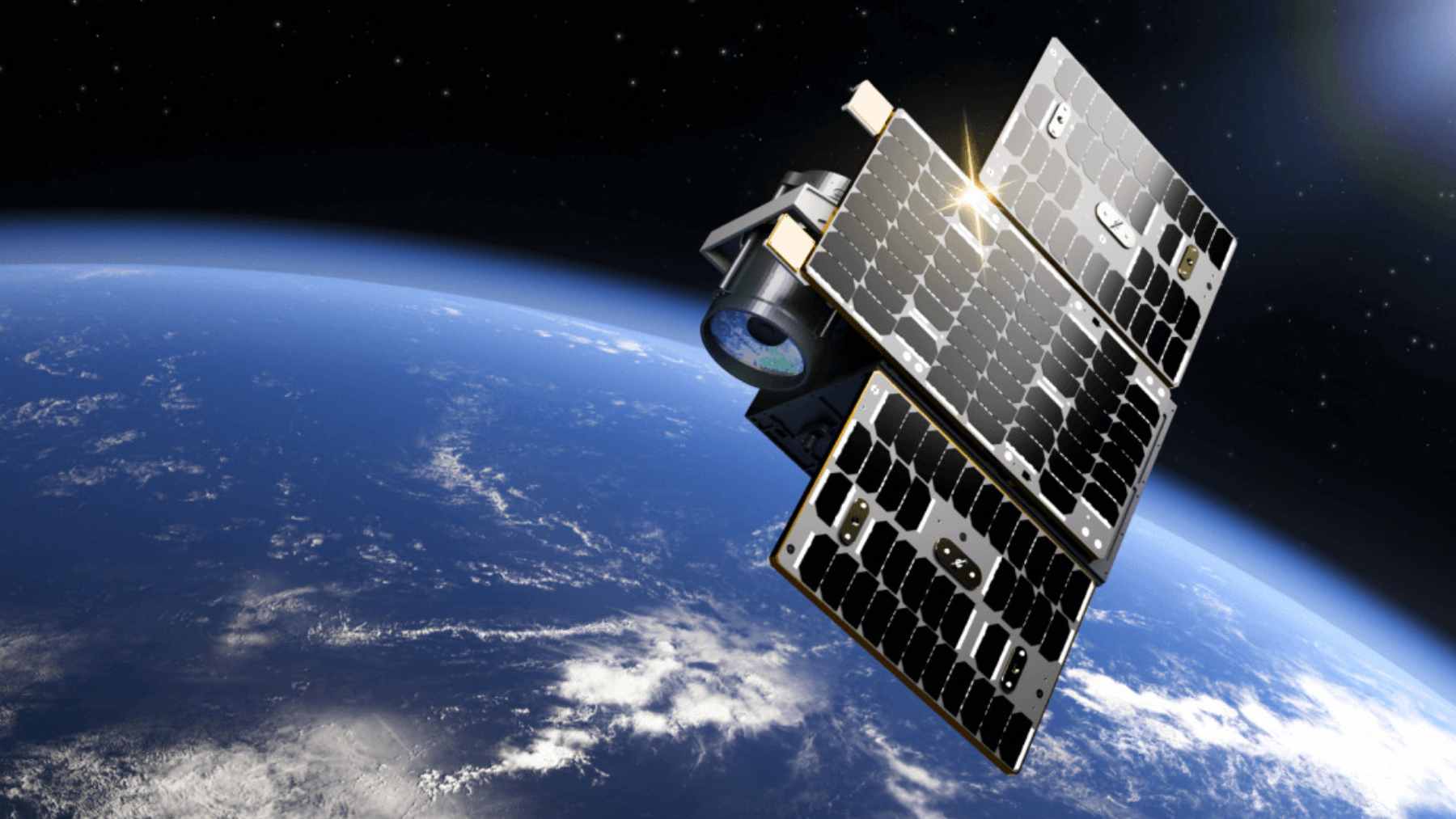 Pixxel co-founder Awais Ahmed standing in front of a model of a hyperspectral satellite, representing the company's contribution to Earth observation.