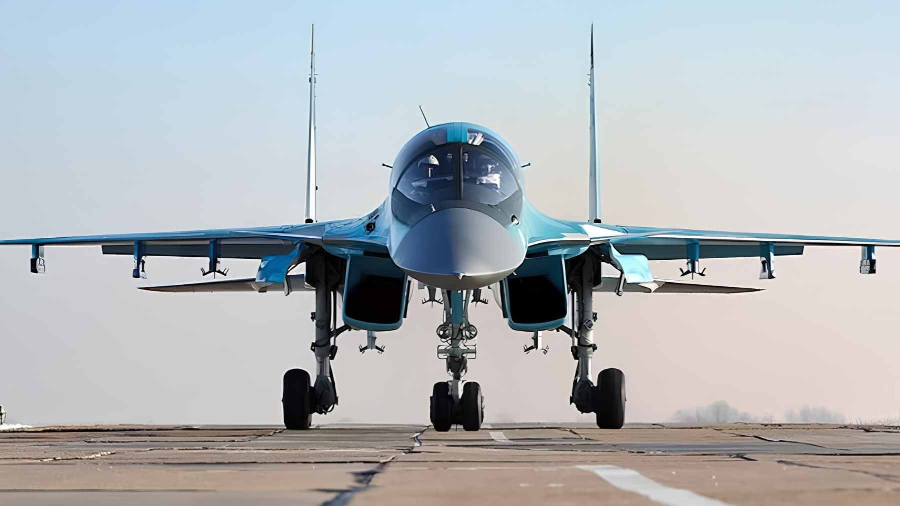 A Russian Sukhoi Su-34 fighter-bomber parked on an airfield tarmac during a military handover ceremony.