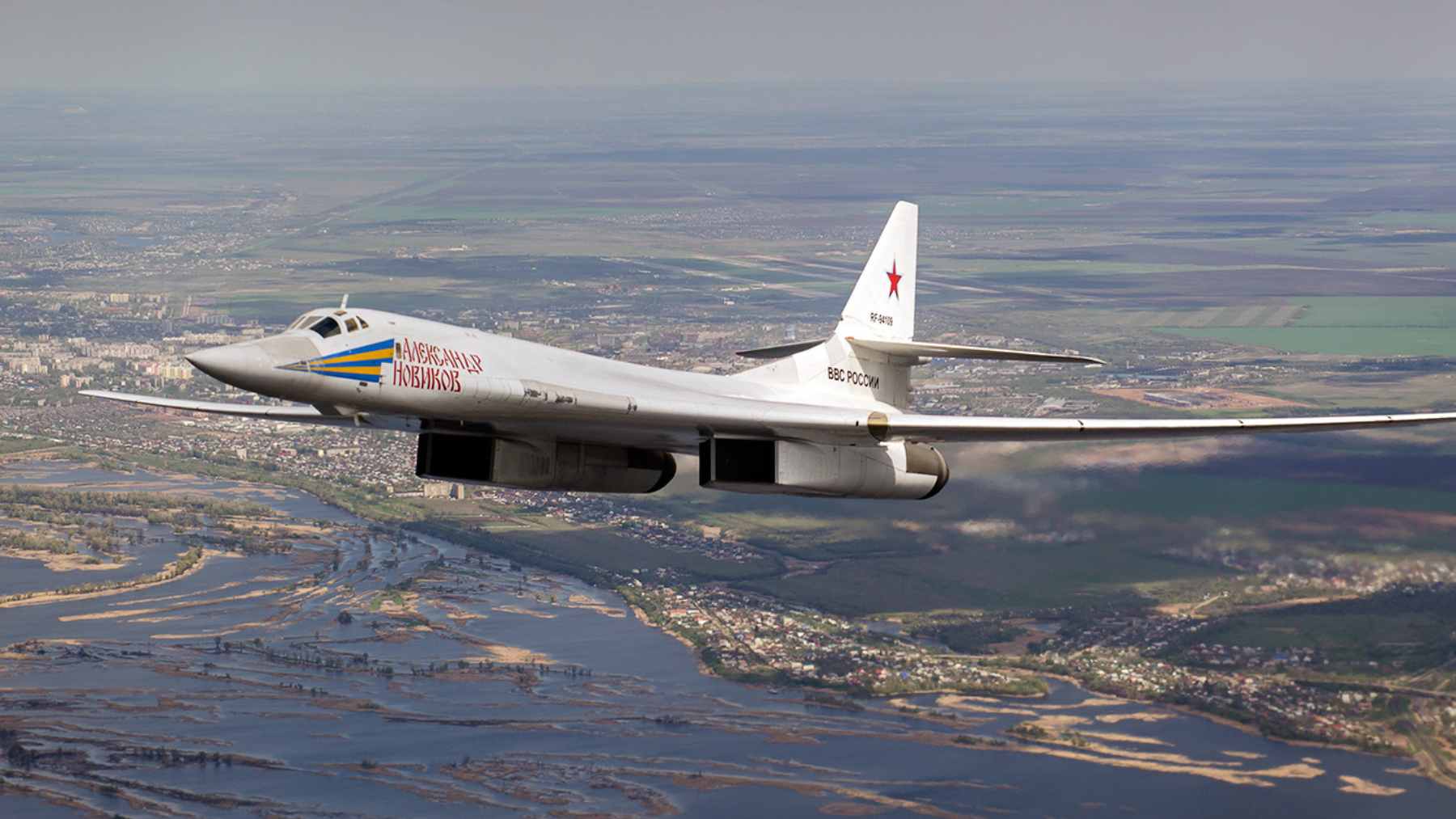 A Russian Tu-160 strategic bomber flying over the Arctic, closely shadowed by a Norwegian F-35 fighter jet.