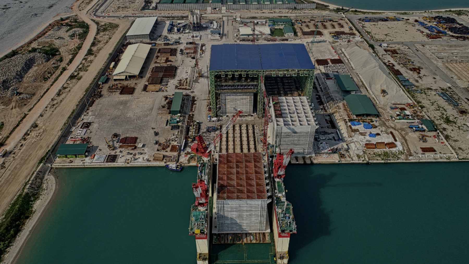 Massive concrete caissons installed along the coastline to form a seawall for the automated Tuas Port expansion in Singapore.