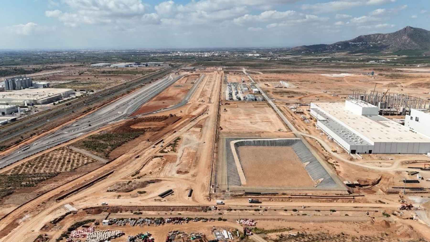 An aerial industrial park view showing logistics centers, warehouses, and green infrastructure in Spain.