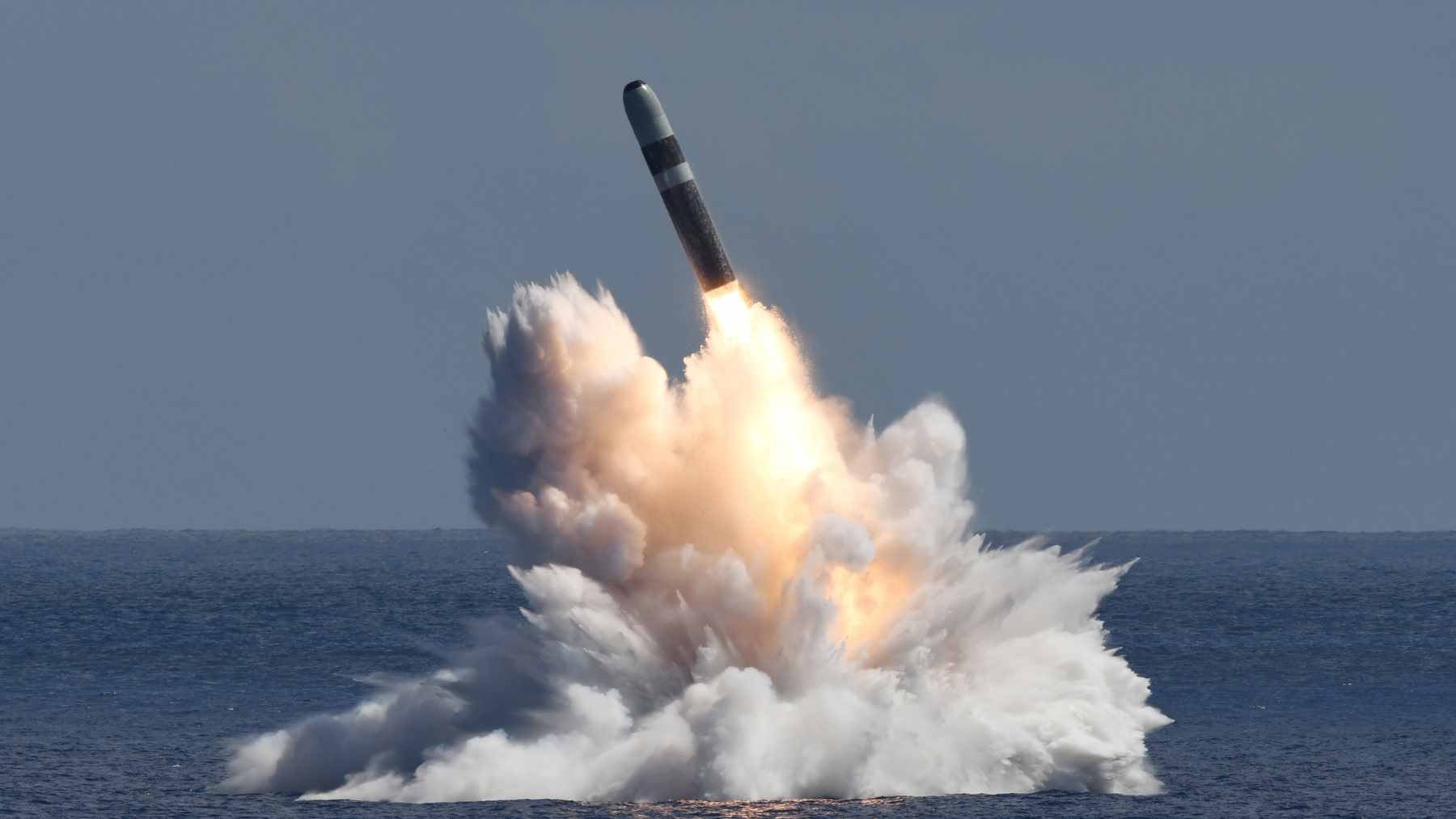 A Trident II D5 ballistic missile emerging from the water during a controlled test launch from a U.S. Navy submarine.