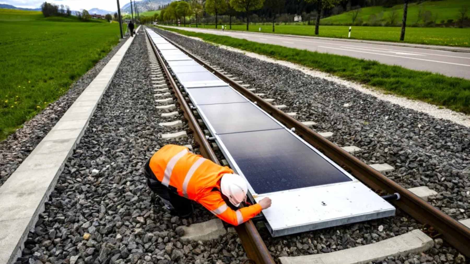 Solar photovoltaic panels installed safely between active railway tracks as part of an innovative clean energy pilot project in Switzerland.