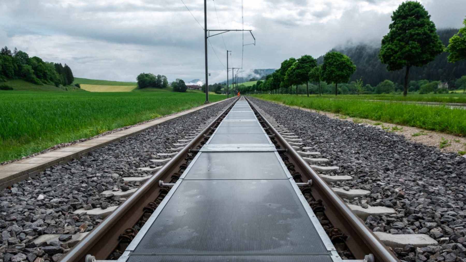 Solar photovoltaic panels installed safely between active railway tracks as part of an innovative clean energy pilot project in Switzerland.