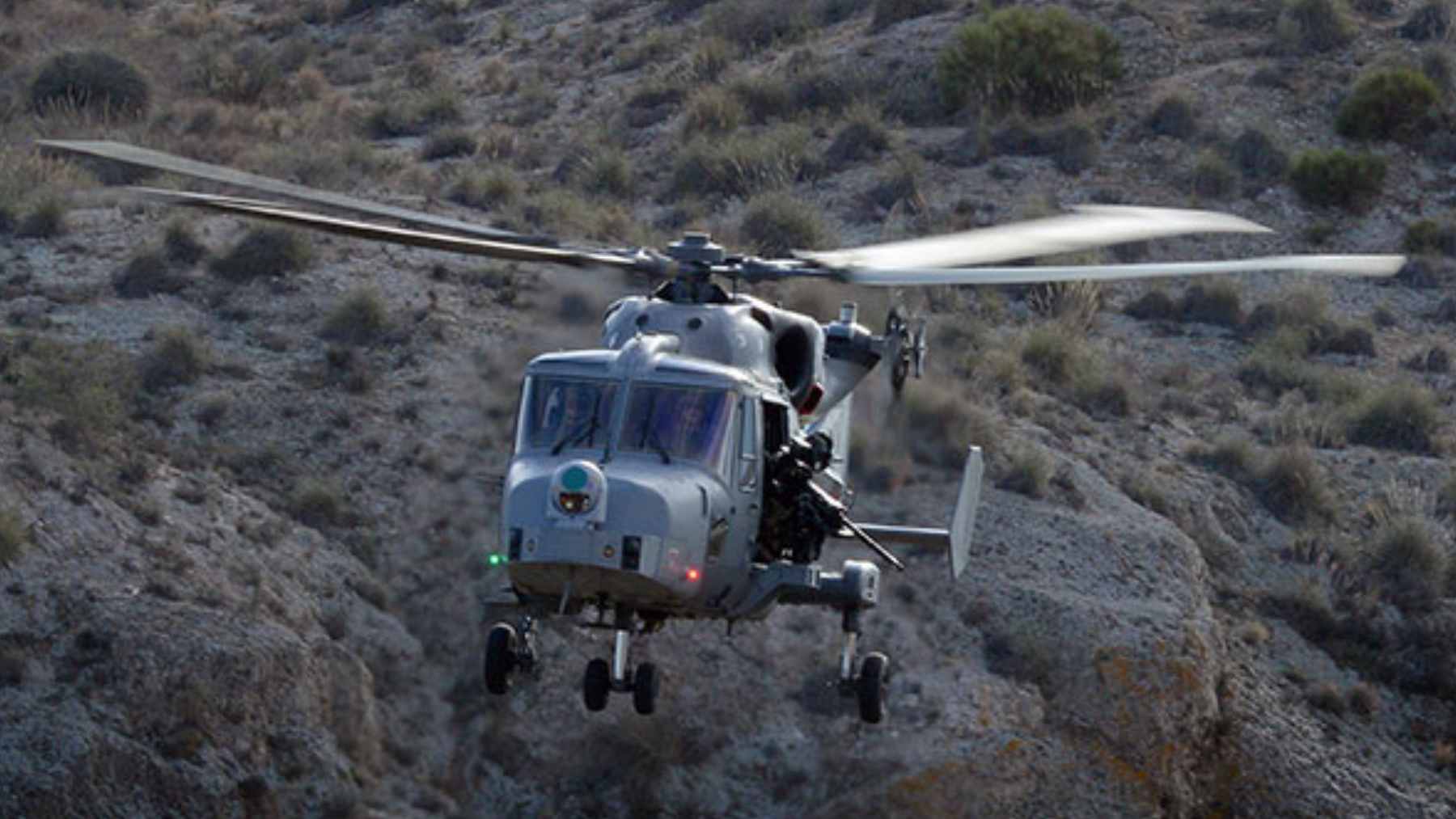 Techy44 1 A British Army Wildcat AH1 helicopter performing reconnaissance training over a rural landscape.