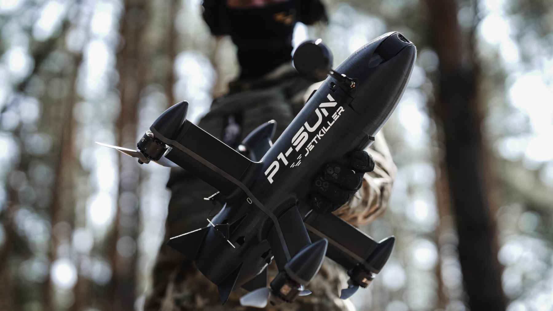 A small interceptor drone flying over a landscape during counter-drone operations against incoming aerial threats.