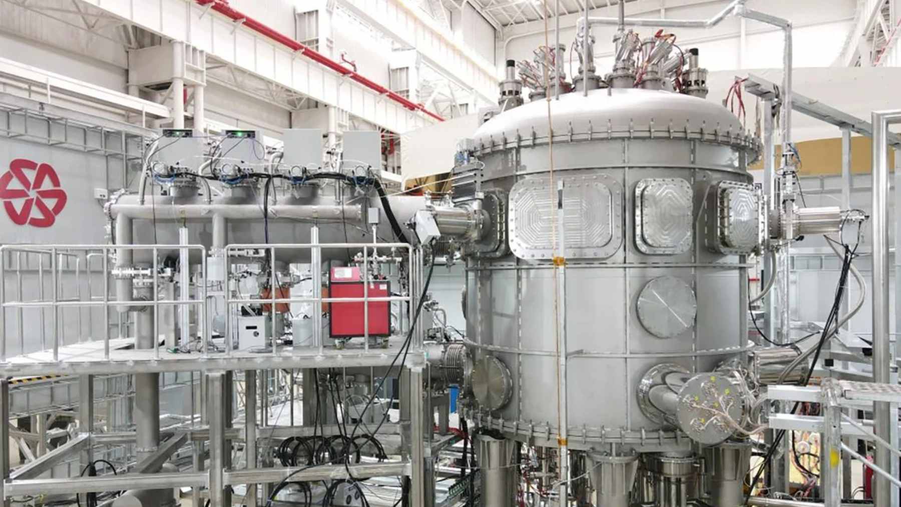 A digital simulation of a tokamak plasma reactor being analyzed on a computer monitor by an AI software platform.