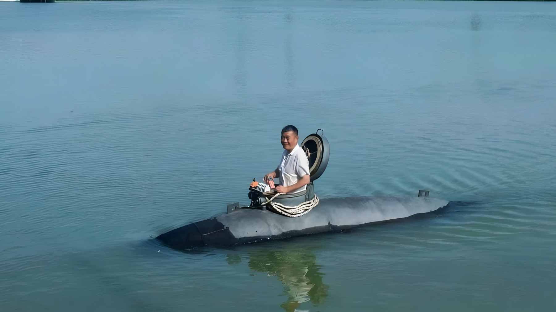 Zhang Shengwu piloting his 5-ton homemade submarine, Big Black Fish, during a test dive in a river in Hanshan County, Anhui.