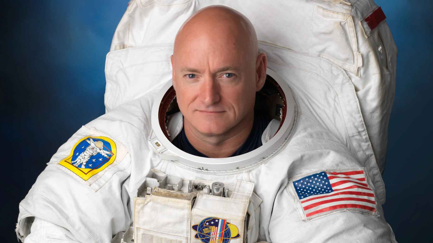 An astronaut in a spacesuit standing on Earth, representing the physical challenges and sensory adjustments of returning from long-duration spaceflight.