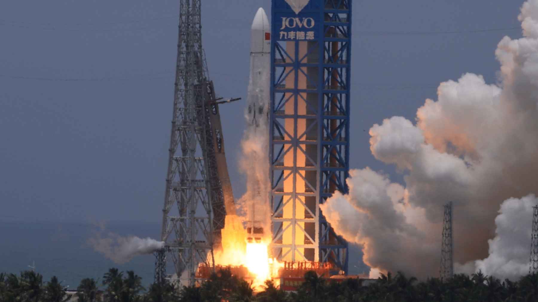 A recovery ship at sea catching a returning rocket booster in a giant net, representing China's aerospace achievement.