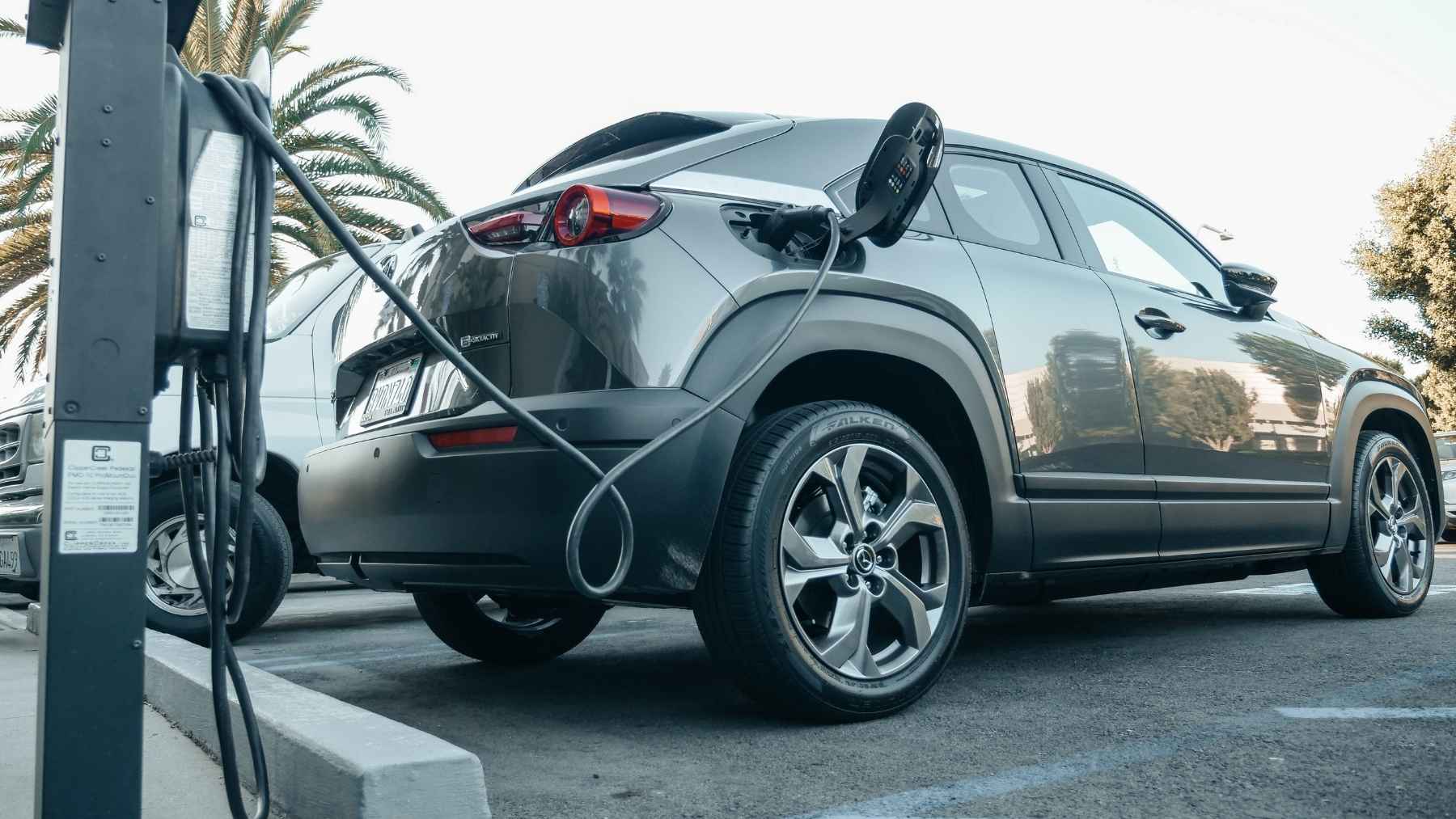 An electric vehicle plugged into a public charging station during a road trip.