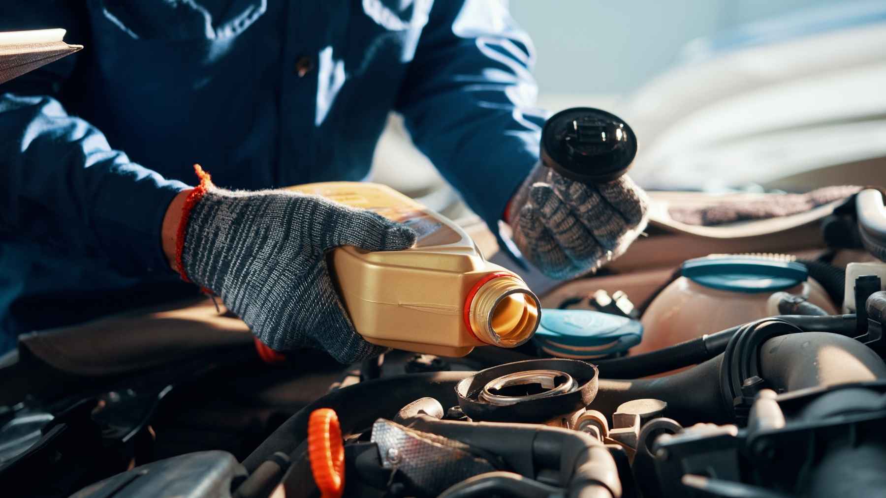 Do the new engine oils shorten an engine's life? One engineer says yes, and his fix has nothing to do with changing brand 1 A mechanic pouring certified motor oil into a modern vehicle engine, emphasizing proper maintenance and viscosity grades.