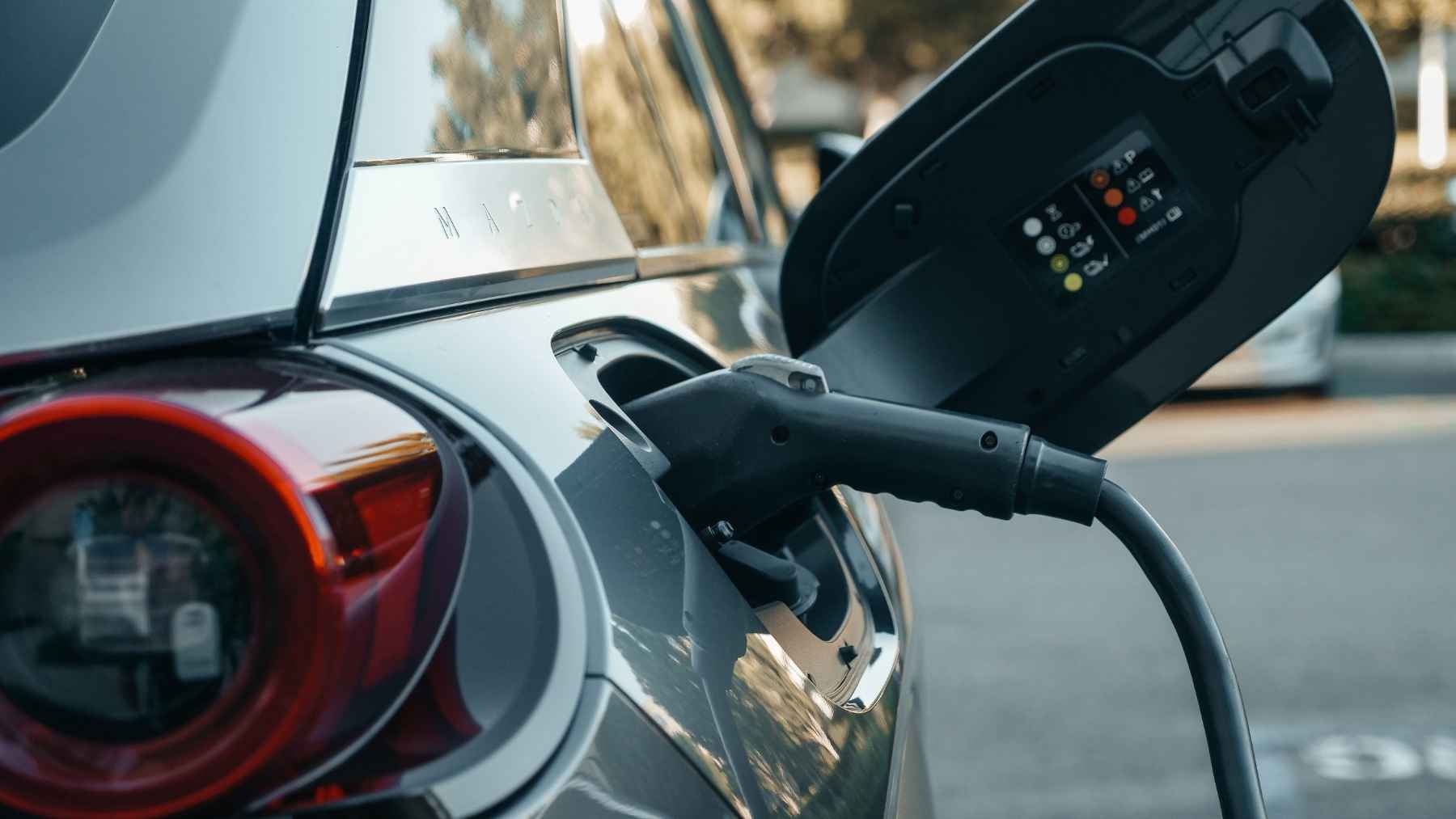 Electric car owners love them with 94% satisfaction, but road trips expose the charging network's weakest link: reliability 2 An electric vehicle charging at a public station, representing the owner experience, infrastructure reliability, and charging network challenges.