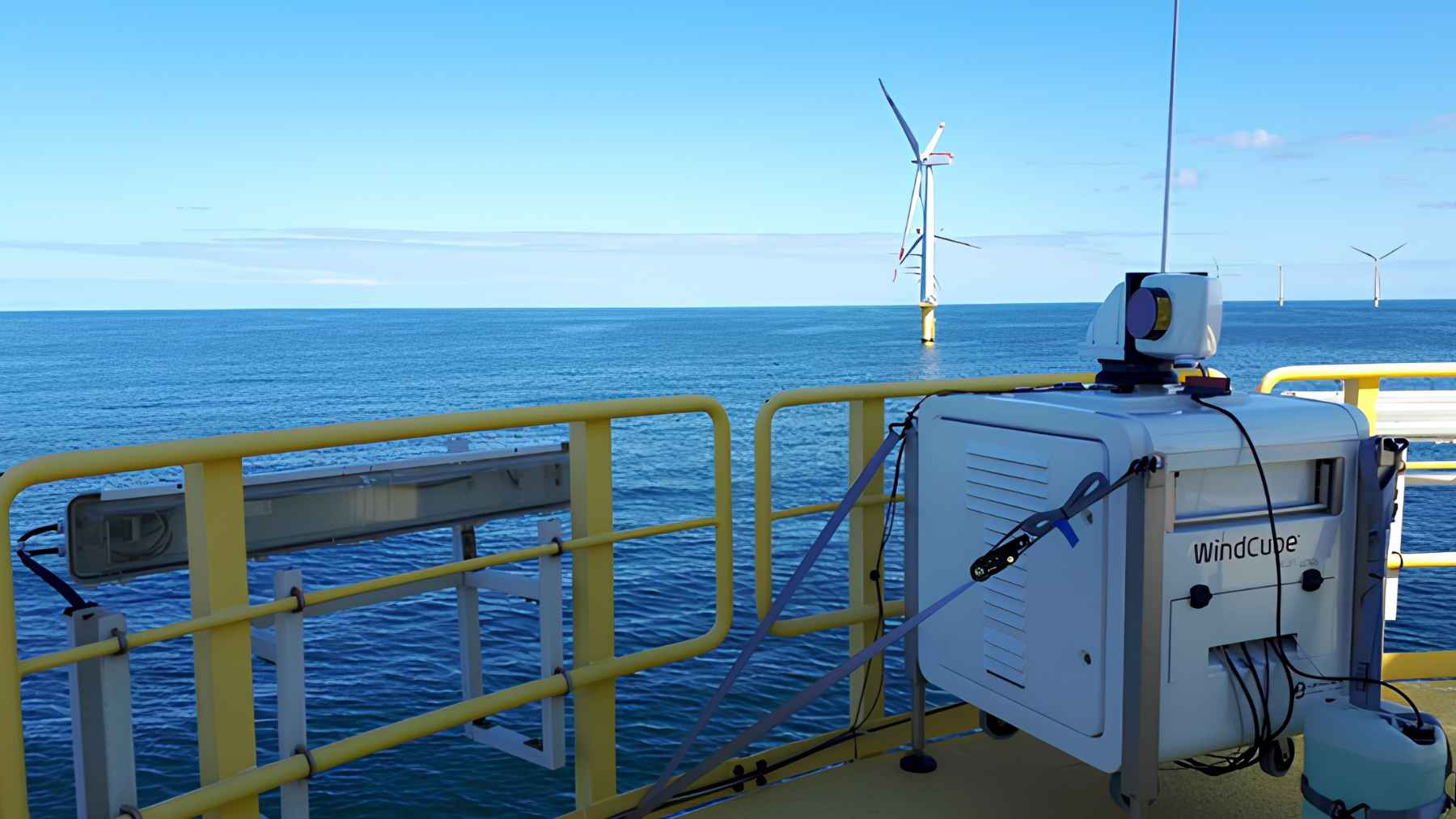 Massive offshore wind turbines operating in the North Sea under a cloudy sky.
