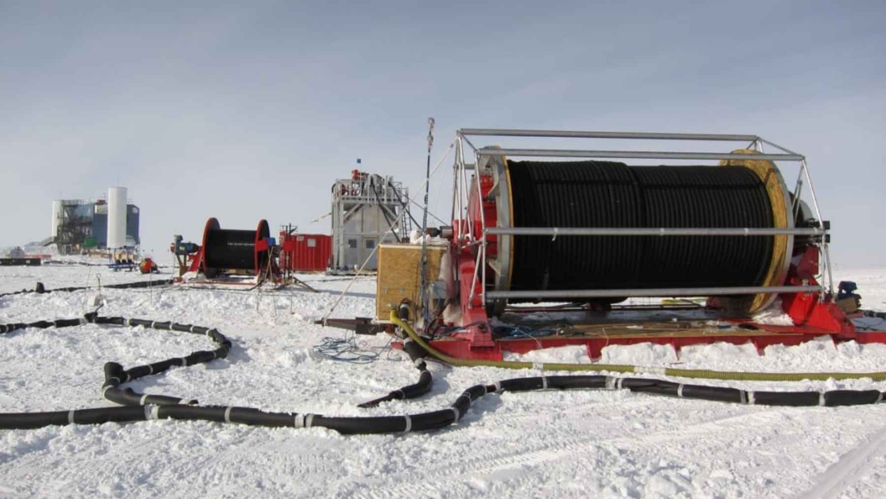 The IceCube Neutrino Observatory installation at the South Pole, featuring vertical strings of sensors frozen deep within Antarctic ice.