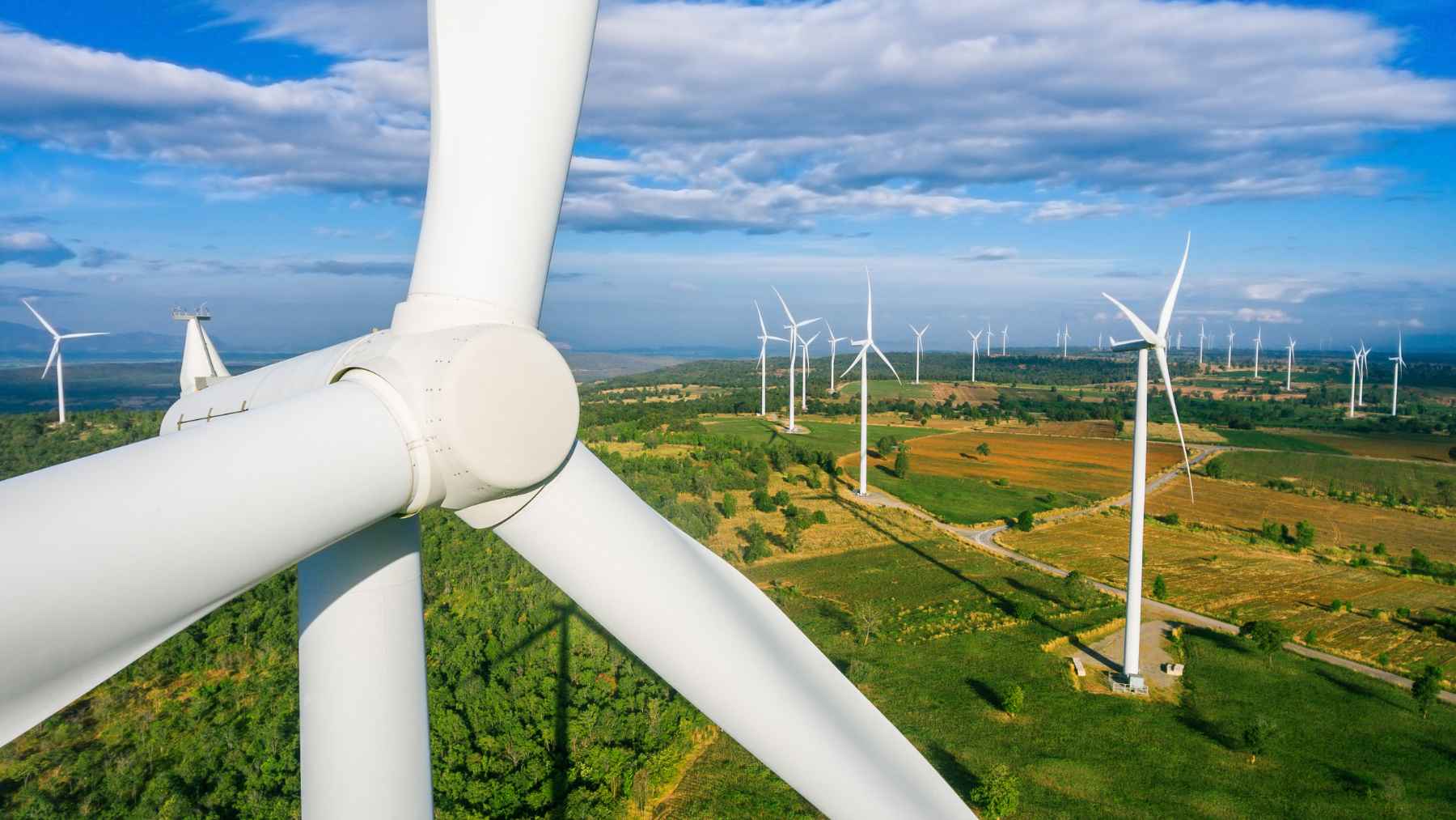Obsolete wind turbines standing in an open agricultural field prior to decommissioning.