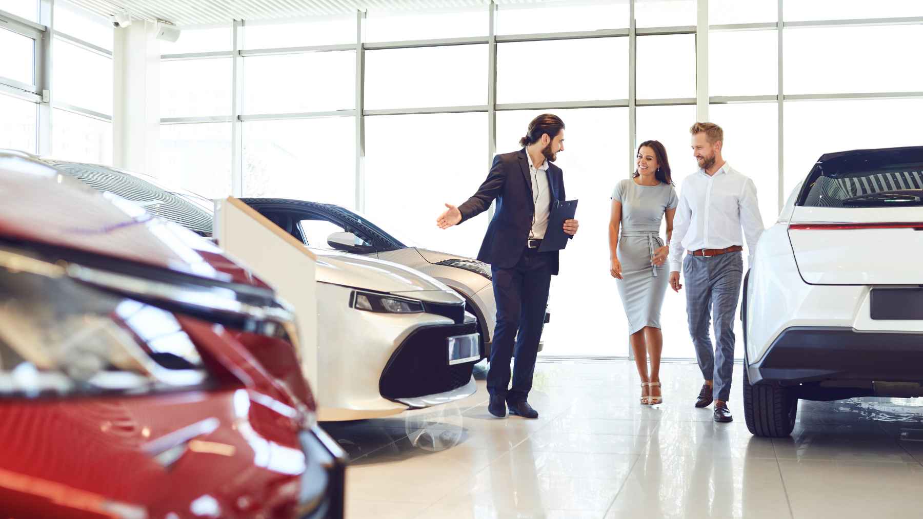 An older adult looking at a new car at a dealership, representing demographic trends in private vehicle registrations.