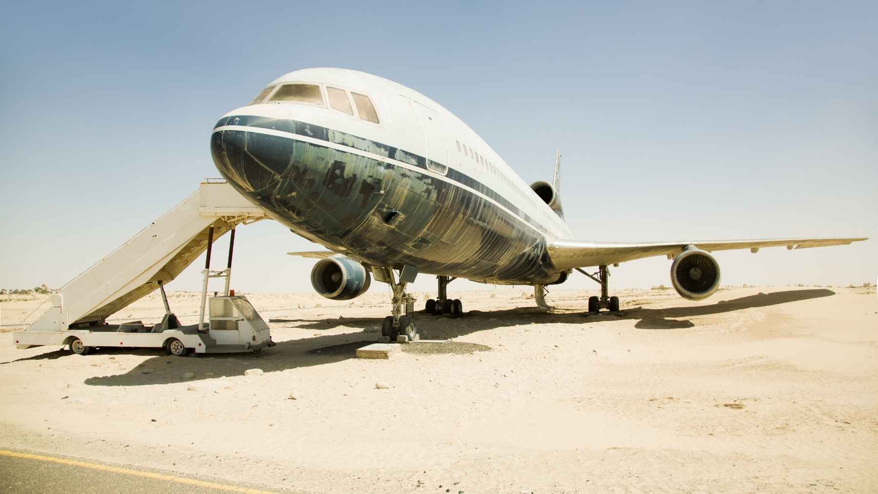 Rows of retired commercial airplanes parked in a desert boneyard for parts harvesting and recycling.