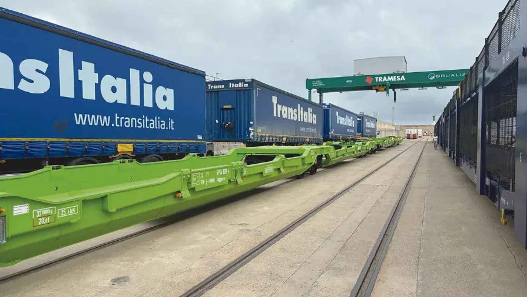 Freight train loaded with truck semitrailers at an intermodal terminal, representing sustainable rail-highway transport in Spain.