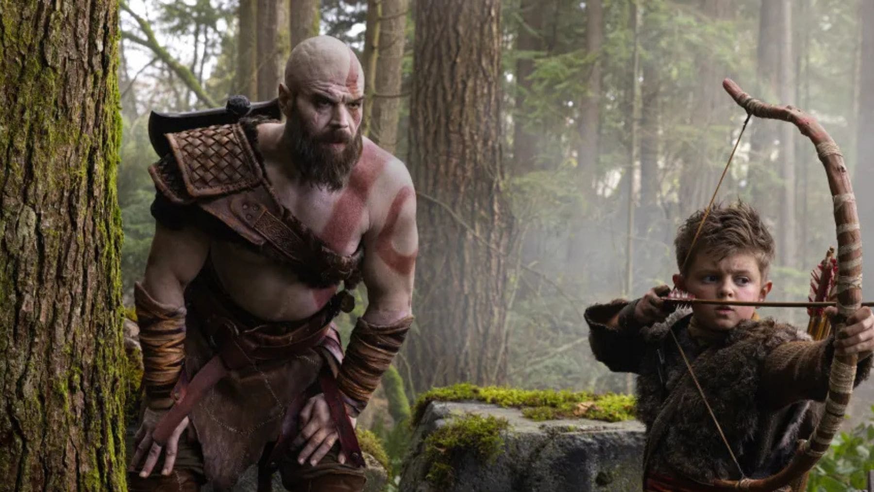 Kratos y Atreus en la serie live action de God of War de Prime Video durante una escena de caza en el bosque.
