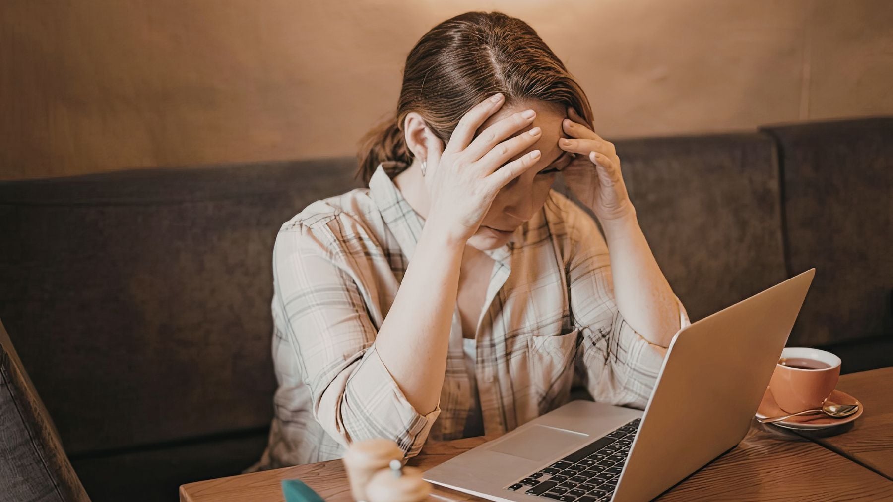 Mujer preocupada frente a un portátil durante una conversación emocional en línea sobre salud mental e inteligencia artificial.