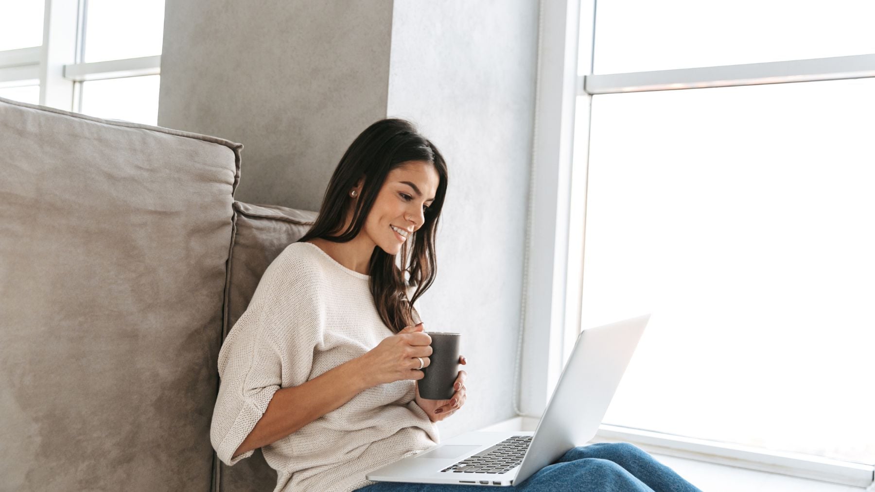 Mujer utilizando un chatbot de inteligencia artificial en su portátil desde casa.