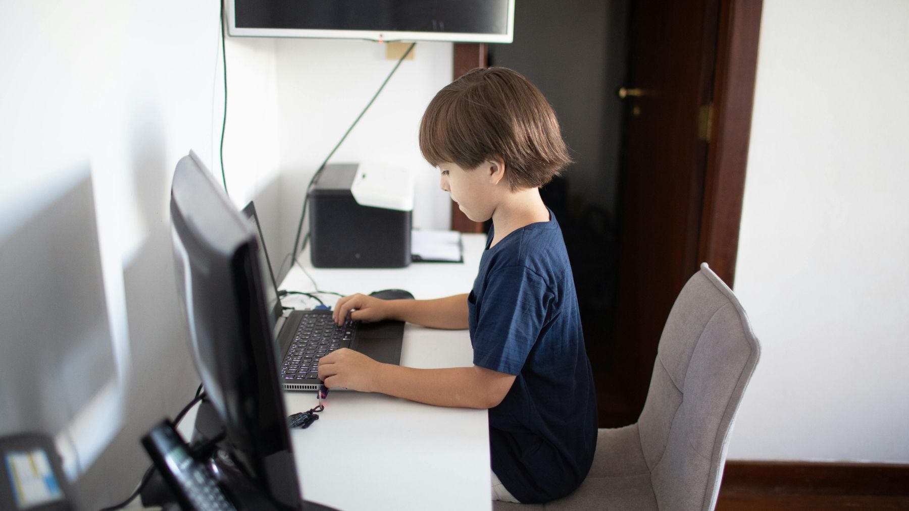 Niño usando un ordenador en casa representando el futuro del trabajo con inteligencia artificial.