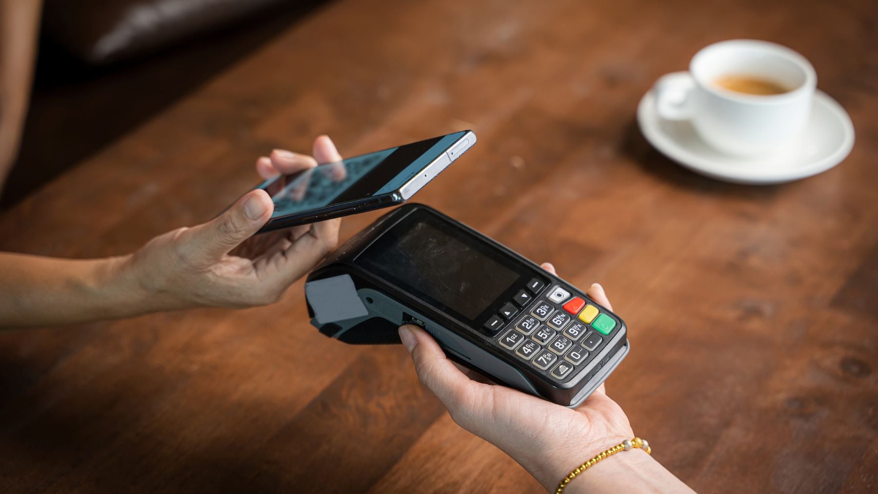 Persona pagando con móvil Android en un datáfono, ejemplo de uso cotidiano expuesto a troyanos bancarios.