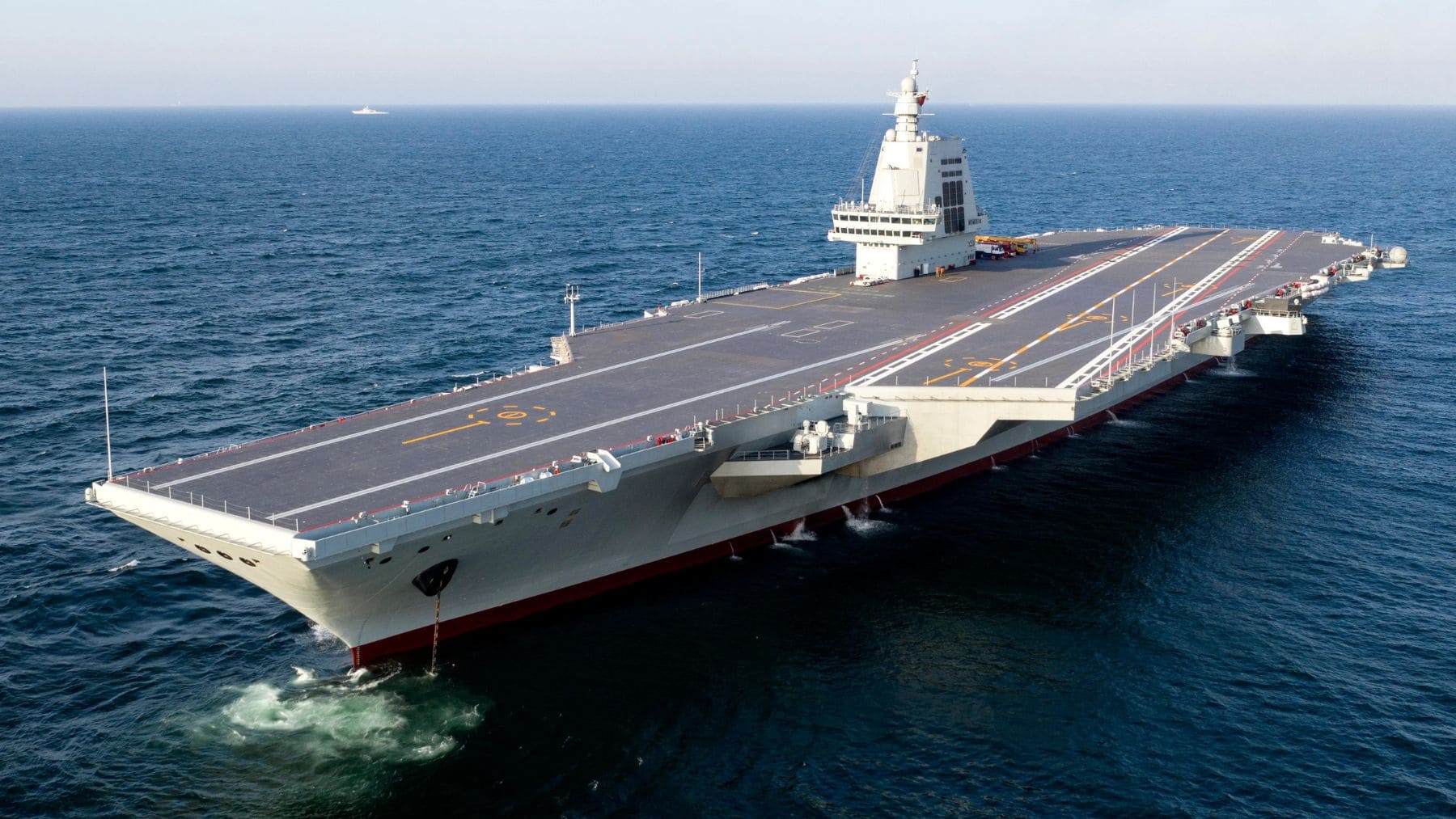 Portaaviones Fujian de China navegando en mar abierto con cubierta de catapultas electromagnéticas.