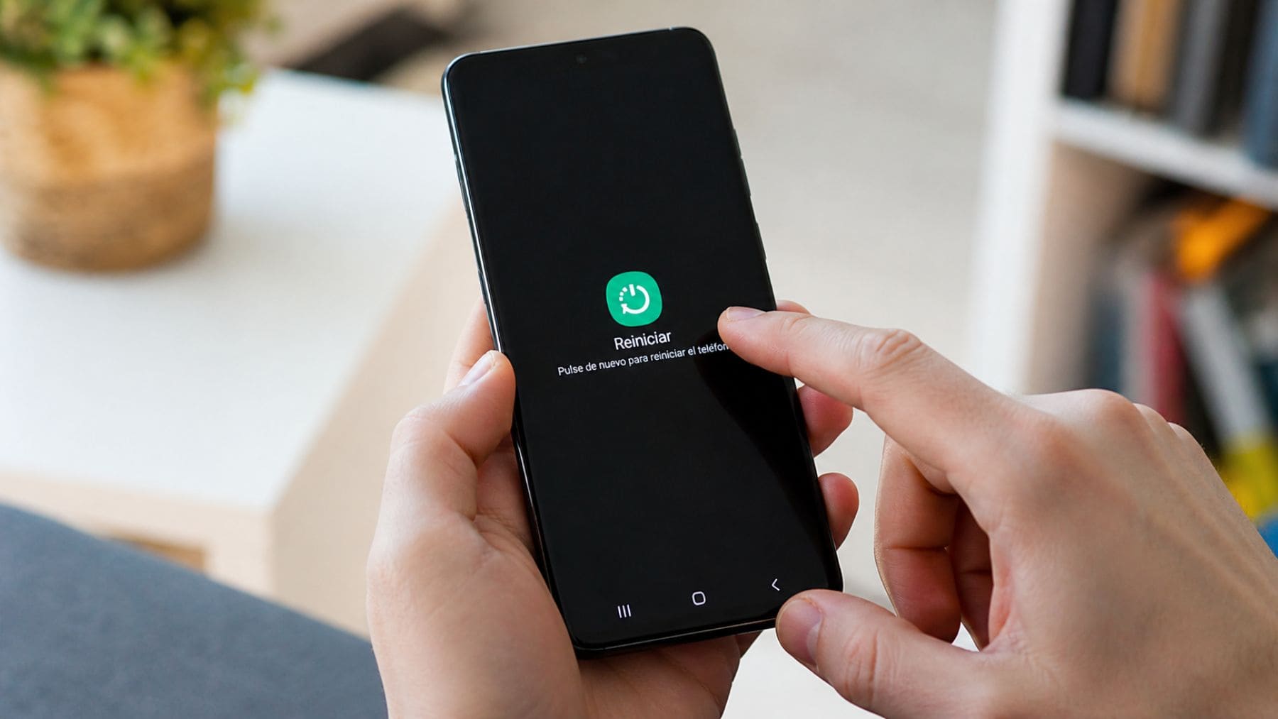 Persona reiniciando un móvil Samsung para mejorar el rendimiento y evitar bloqueos.
