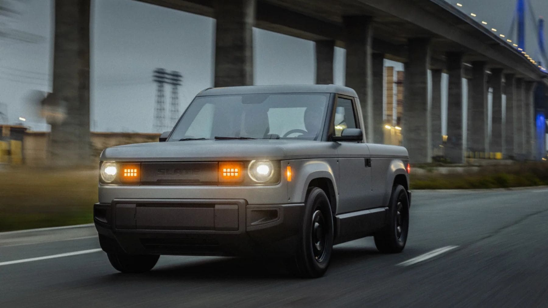 La pickup eléctrica asequible de Slate Auto circulando por una carretera urbana en Estados Unidos.