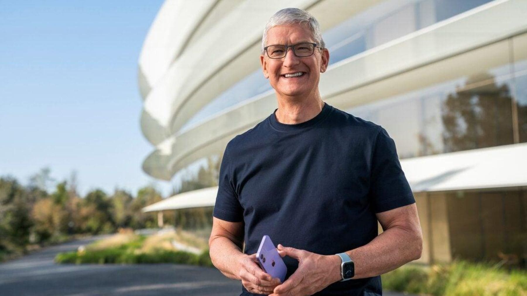 Tim Cook sosteniendo un iPhone frente al Apple Park durante una entrevista sobre el uso excesivo del móvil.